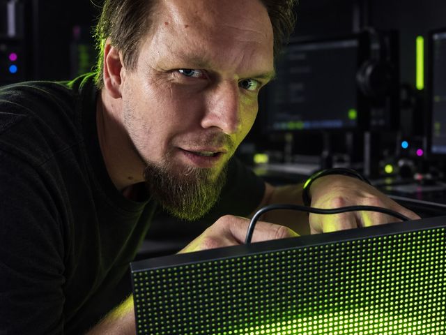 Průvodce v dílně drží rozsvícený LED panel